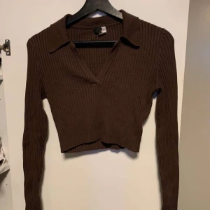 Kort tröja med urringning  - Snygg kort tröja Andvänd 2 gånger. Köpte för 250 och den säljs inte mer. Säljer för att jag inte gillade urringningen och tar aldrig på mig den. Den sitter åt i midjan och ärmarna är långa.
