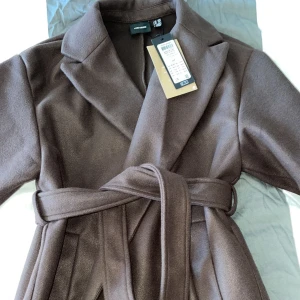 Kappa - Brun lång kappa från veromoda. Helt ny. Super fin men tycker inte alls den satt fint på mig. Frakt 50kr. Tryck ej på köp nu. Skriv för fler bilder!