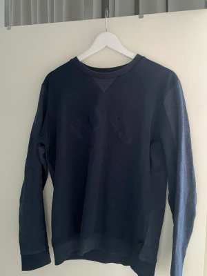 Hugo Boss Tröja - En blå Hugo Boss tröja i storlek Medium. Som nyskick. Väldigt skönt material. Köpt i NK Stockholm.