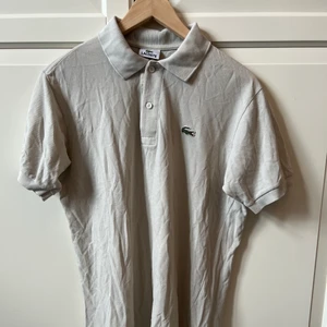 Lacoste piké  - Säljer en beige Lacoste piké köpt för 300 på en secondhandbutik säljer den för 100