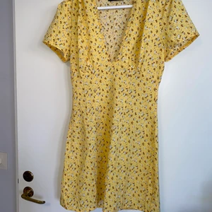 Klänning  - Ljusgul blommig klänning. Tightare upptill men en jättefin ganska djup urringning 🤍 