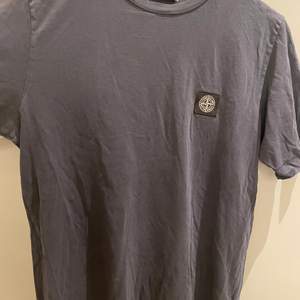 Fin mörkblå stone island T-shirt i junior storlek. Skulle säga att motsvarigheten är en xxs-xs i unisex modell. Använd men mycket fint skick och inga defekter!