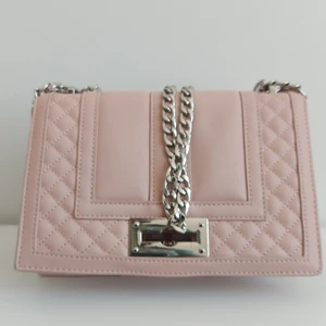 Rosa axelväska - Rosa axelväska med silverfärgad kedja. Ett fack med dragkedja på insidan samt 2 öppna fack. I väldigt bra skick. Priset är exklusive fraktavgift. 