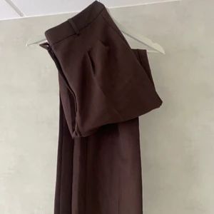 Kostymbyxor  - Brun/lila högmidjade kostymbyxor. I mycket bra skick, säljs då jag ej använder dom längre. 