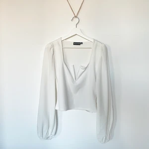 Festlig vit topp - En väldigt fin och festlig topp från prettylittlething. Använt endast under en utekväll så tröjan är i nyskick.   Den är V ringad och har puffiga ärmar. Eftersom den är lite mer i cropped stil köpte jag storlek 40 för att den skulle täcka magen lite mer men passformen passar dig som har M. Den är inte genomskinlig men rekommenderar att ha vit BH under ändå ☺️