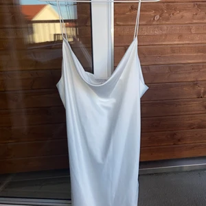 Ursnygg vit klänning i silke.  - Perfekt klänning till studenten eller till sommaren!!. Köpt från topshop i London. Kan justeras i längd med hjälp av detaljen på sidan. 