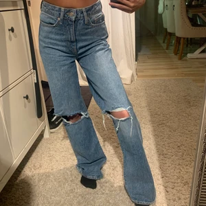 Blåa jeans med hål i knäna - Blåa jeans från lager157, knappt använda. Tajta i midjan och pösigare i benen. Lite långa på mig som är 154. Säljer för 150kr