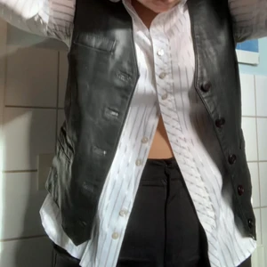 Läderväst - Mer åtsittande läderväst inköpt second hand. Har använt som topp utan något under fåtal gånger. Tänker att den kan passa som mer oversize väst på XS-S och som en mer åtsittande topp på L-XL.