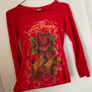 Ed Hardy långärmad tröja  - Säljer denna röda Ed Hardy tröjan. 🌹🥀❤️🖤 Det står storlek 11 på en lapp i den men vet inte riktigt vilken storlek det är. Uppskattar till en XS/ S. Alternativ barnstrl Nästintill alla paljetter är kvar. Någon kanske har fallit av men det märks inte. Finns små hål på baksidan av en ärm. (Se sista bilden.) Och texten har skavts av på vissa ställen. Kan inte visa på för den är för den är inte i min storlek :(  ( Osäker på om den är äkta då jag köpt den second hand.) Tar swish och fraktar spårbart! 😇