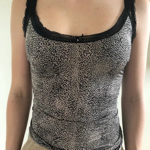 Leopard linne med spets - Jätte fint leopard mönstrat linne med svarta spets kanter. Har en tajt passform och en liten rosett där fram.  Säljer pågrund av att jag inte har användning av den längre