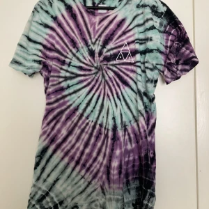 Tie dye HUF t-shirt  - Snygg t-shirt från HUF i tie dye mönster. Tror det är en herr t-shirt, men har funkat fint som en oversize för mig (tjej, storlek 36 normalt). Trycket har lite sprickor, samt den är nopprig på vissa ställen. 