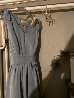 Klänning  - Klänning från JJ’s house!  Väldigt fint skick och endast använd vid 1 tillfälle!  Perfekt till stundent och andra evenemang under sommaren! Den är väldigt anpassningsbar i storleken eftersom det är knytning i ryggen med ett brett band🥰 Prutmån!