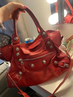 Balenciaga City Bag - Säljer min Balenciaga röda city bag. Säljs då jag tyvärr inte fastnade för för den. Köpt i vintagebutik i Göteborg. Använd väskan en halv dag. Köpt för 6000kr. PM vid frågor/funderingar 💞