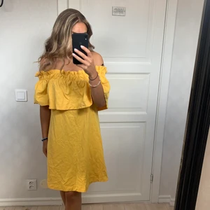 Gul klänning - Axellös klänning i skönt bomullsmaterial med fickor på sidan