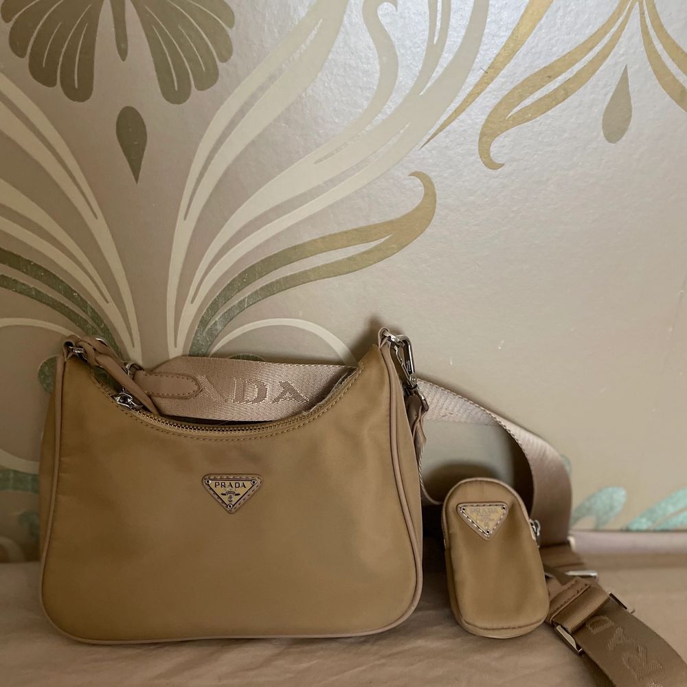 Prada re edition 2005 nylon bag in beige. Such a great bag! I love it. Selling for this cheap due to the torn lining, but not visible from the outside. Otherwise in great condition. . Some small stains on the back, I can send more pictures to you. . Väskor.