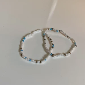 Armband - Armband från indiska med elastiskt band. Med vita, blåa och guldiga pärlor. (Kan användas till att ha på ankeln)