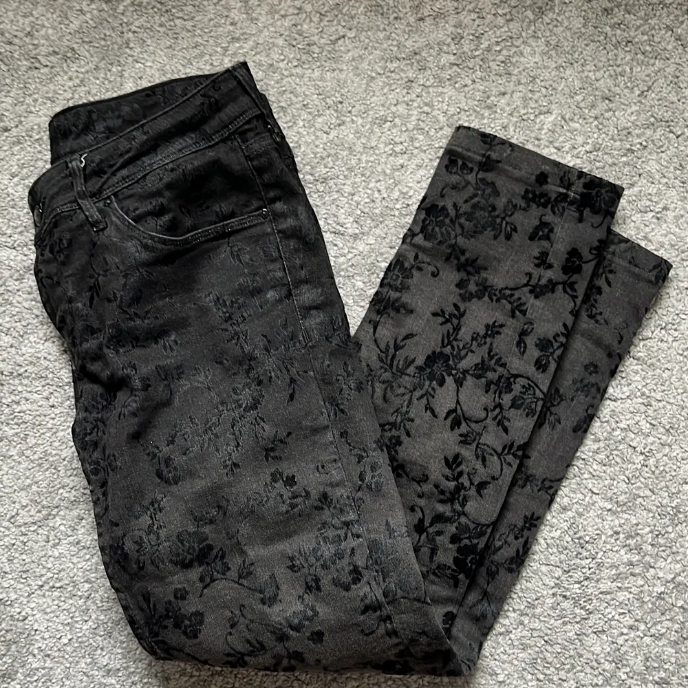 snygga vintage lågmidjade jeans. de är svarta och har ett blommönster typ 💗 skriv priv för mer bilder 💋 CN 165/76A, . Jeans & Byxor.