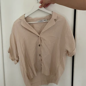 Kortärmad skjorta - En fin beige kortärmad skjorta från & other stories med stora bruna fina knappar. Köparen står för frakten. 