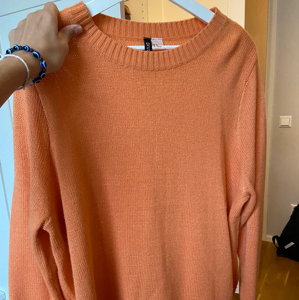 Orange stickad tröja från hm. Står XL men sitter bra på mig som är en 36/38. Neuleet.