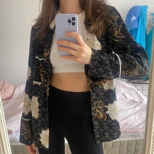 Blommig blus - Asgo blommig blus från Gina Tricot. Den är i tunt material som imiterar satin. 