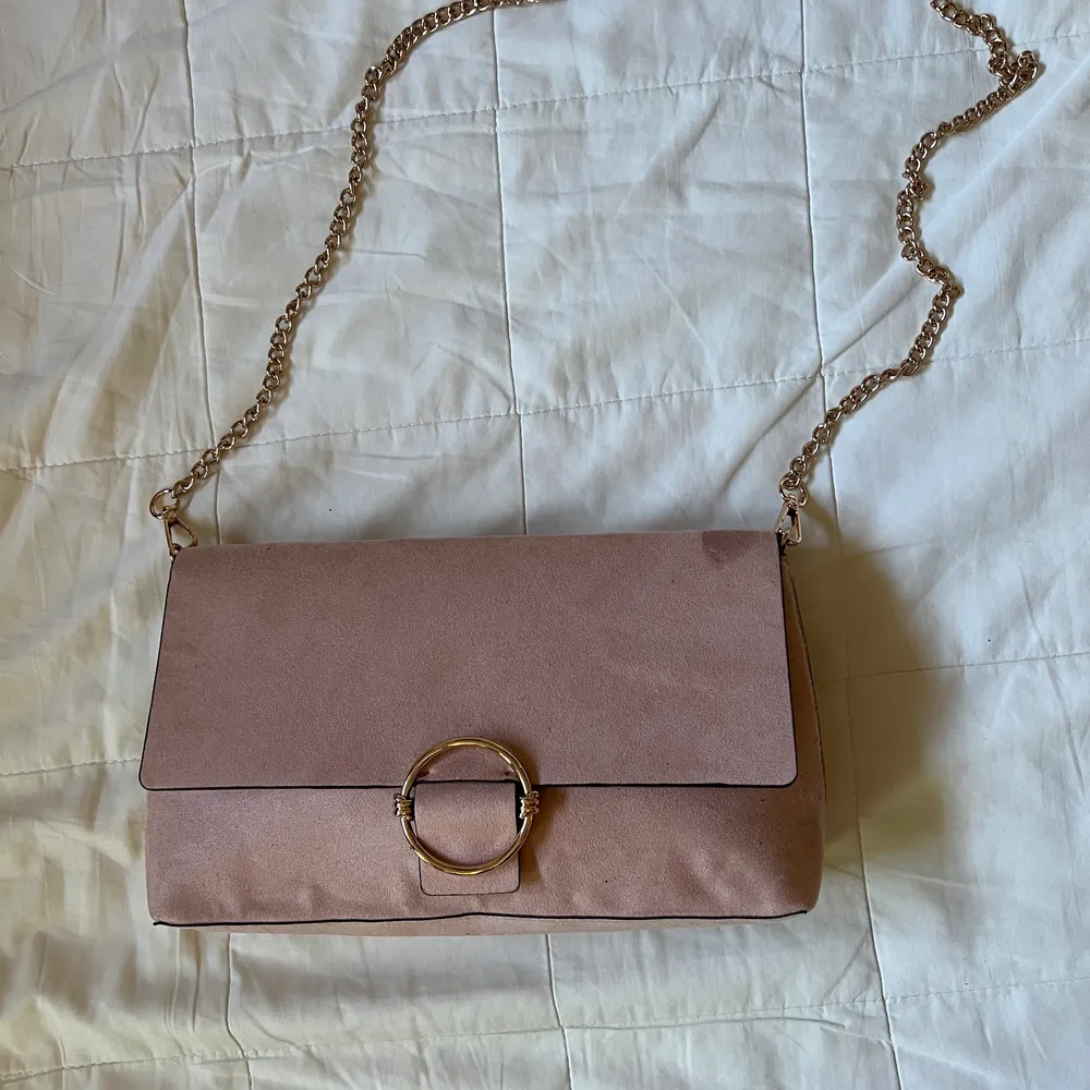 Rosa väska från H&M med kedja i metall som är avtagbart. Måttet på väskan är 6x15x27 cm.. Väskor.