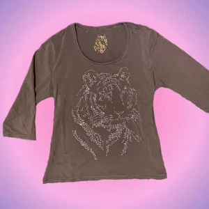 Brun tröja med rhinestones - Så snygg och trendig brun trekvartströja med coolt tryck och rhinestones😩🫶🏻 Säljer pga den tyvärr inte kommer till användning! Alla rhinestones är kvar och tröjan är i fint skick. Skulle säga att den passar bäst på S-M. Skriv privat vid intresse o frågor😊🤎