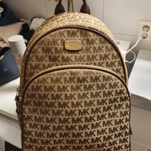 Michael Kors Ryggsäck - Äkta Michael kors ryggsäck i ljusbrun/brun/guld i iprincip helt nytt skick! PM för mer bilder