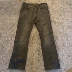 Levi’s Jeans - Ett par gråa Levi’s jeans som aldrig är använda och är därför i bra skick.