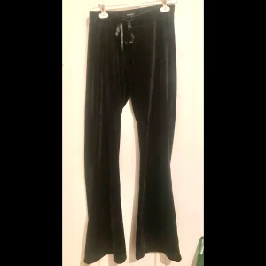 Svarta sammetsbyxor med knytband i midjan  - Jättesköna sammetsbyxor med snyggt fall. Längd 106cm Innersöm 77cm Knappt använda.