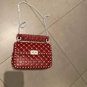 Valentino rockstud väska  - Säljer min jättefina valentino väska som jag köpte för ca 2 år sedan. Väskan är jättefin och funkar utmärkt men den har fått lite skador som kan ses på tredje bilden också därav det lite lägre priset.