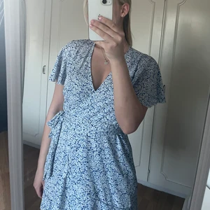 Blå klänning - Säljer denna blå blommiga klänning, endast använd en gång så i jättebra skick, storlek S. Köparen står för eventuell fraktkostnad