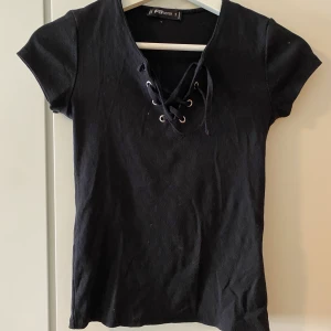 Topp från NewYorker  - En fin topp från NewYorker med en v-ring och snören, använd ett par gånger och är köpt för något år sedan, har nu dock blivit för liten för mig att använda.