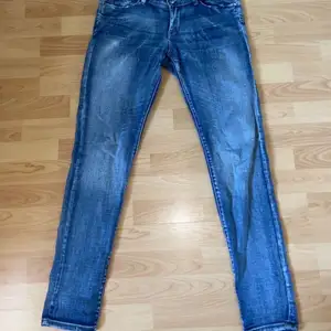 Ett par blåa jeans lågmidjade. Vet ej storlek men skulle tro en 34 typ. Lite slitna här och där men inga hål vad jag kan se. 