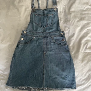 Jeanskjol med hängslen  - Fin jeanskjol med hängslen, väldigt bra skick eftersom den bara är använd vid ett tillfälle. Storlek 36. 