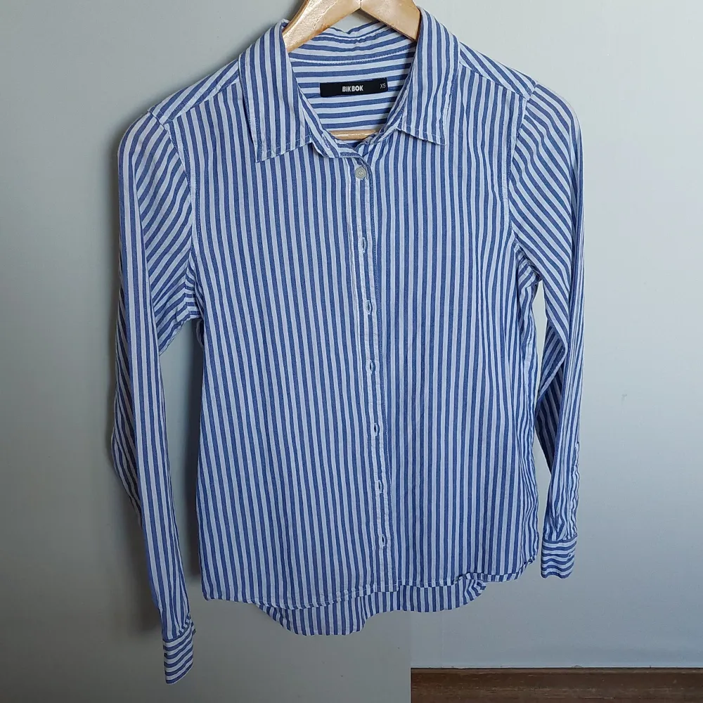 Säljer min blåa skjorta från Bikbok. Har använts ett par gånger men säljer pågrund av att den inte används längre. Passar perfekt för sommaren och våren!!      Storlek: XS      Pris: 105 kr. . Skjortor.