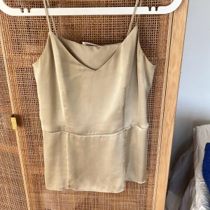 Beige linne från Arket - Ett trendigt och vackert linne med silkeseffekt från Arket, knappt använt. 100% polyester men så så lent och fint. Skick utan anmärkning! 