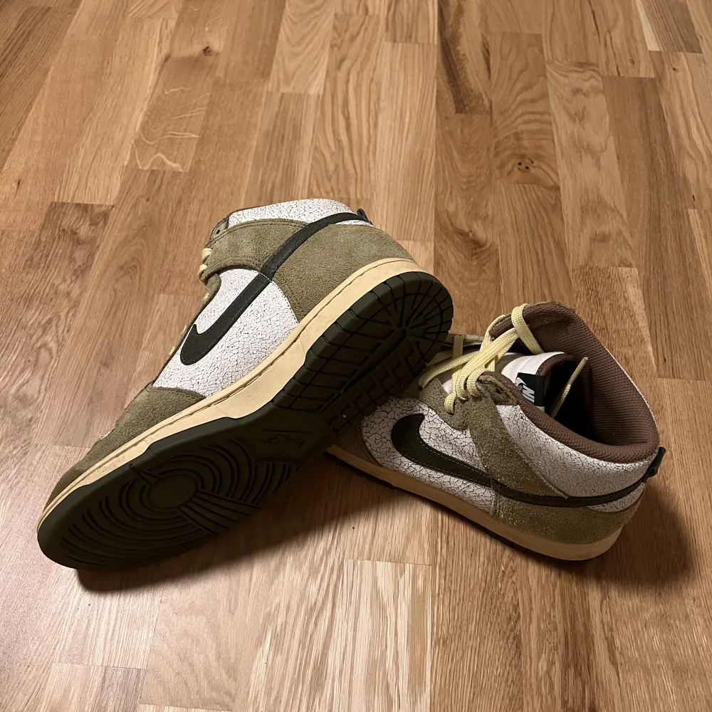 Nike dunk High i färgerna khaki grön och brun. Kommer med box, skorna är i skick 9/10. Knappt använda så inga defekter. För att vara tydlig så ska de se använda ut, de ska se spruckna och gula ut. Köptes för retail: 1600kr på footlocker. . Skor.