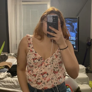 Blommigt linne - Rosa blommigt linne från FBsister. Storlek S men passar även M. Banden är väldigt långa för mig som har kort överkropp.