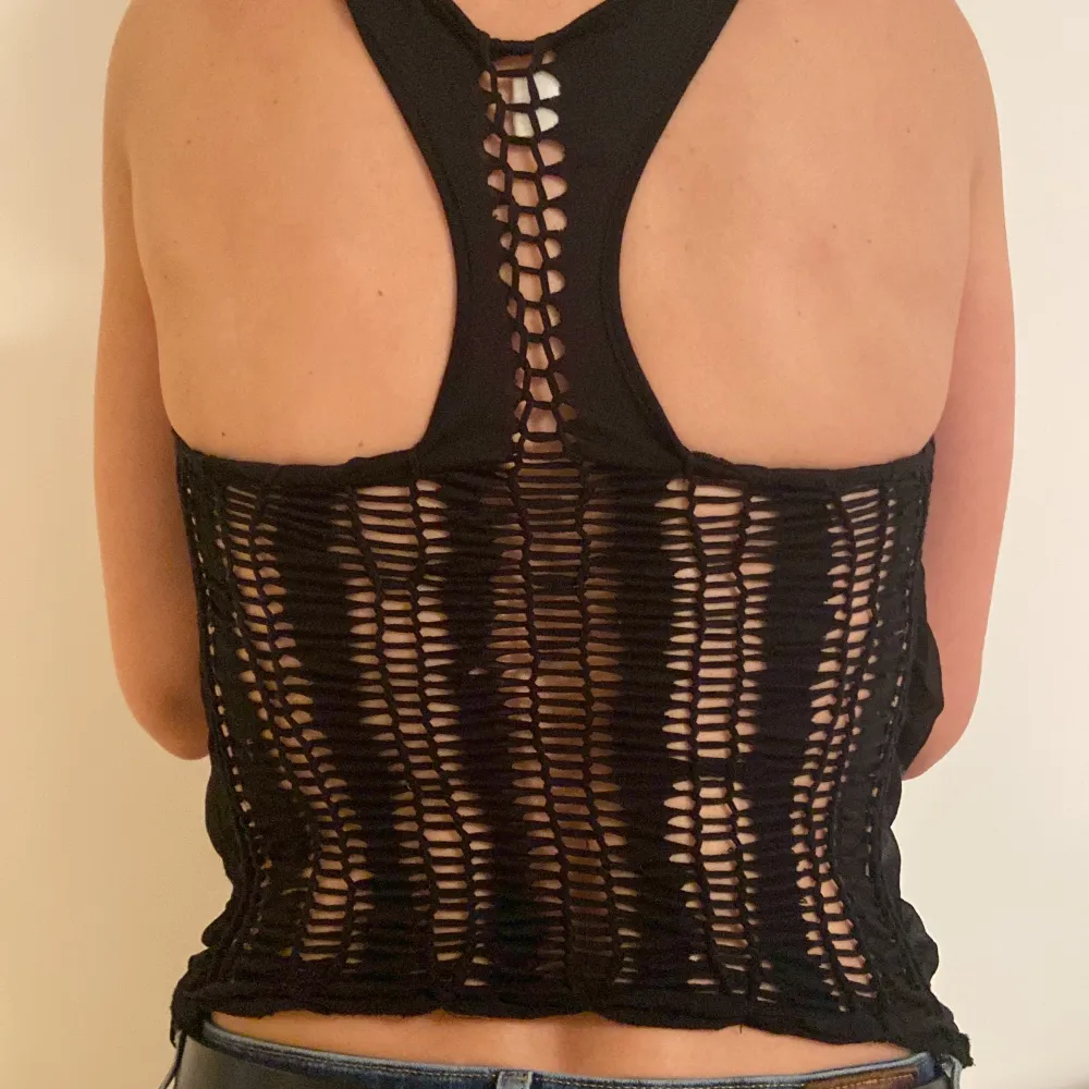 Religion tank top, black with layers. The under layer is stretchy with holes (as seen in photo) the top layer on the front is light and has a small design on it. It is a size S. Fits great if you are around 170cm. . Toppar.