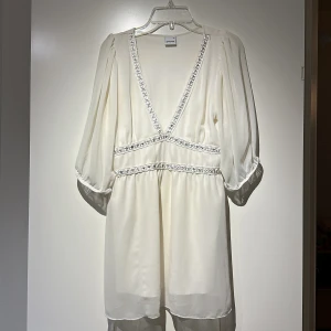 Klänning - Kort klänning med Trekvarsärm.  Några små fläckar på höger sida som är obehandlade, såg de först nu. Välanvänd men har mycket kvar att ge, därav så billigt pris. 