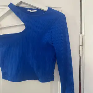 En one shoulder tröja i ribbat material och en härlig blå färg. Storlek S. Använd endast en gång! Köpt på Macy’s i New york.