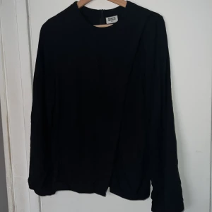 Svart blus - Svart blis med en slgs ”slits”. Tar fler bilder vid önskemål😊 Från weekday, inga tydliga tecken på användning. Strl S.