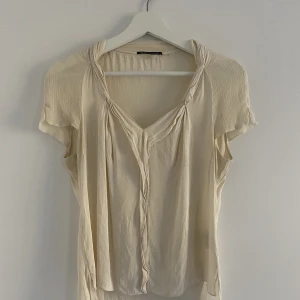 Elie Tahari topp s silke  - Silkestopp från märket Elie Tahari i gräddvit färg. Fint skick, inga skador. 