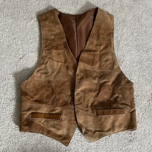 Brun mockaväst  - Köpt second hand, bra kvalite. Har tryckknappar och spänne bak✨ Passar S/M