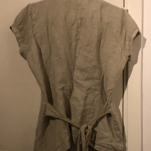 Grön  skjorta  - En stilig grön skjorta med fina design i armarna. Passar bra för sommaren. Skjortan är markerad  L som storlek men skulle även kunna markeras som M. 