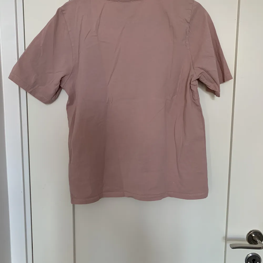 En dovt rosa lätt oversized T-shirt med tryck på en kvinna med blommor. Tröjan är använd men i bra skick. Säljer då den inte riktigt är min stil längre🤍. T-shirts.