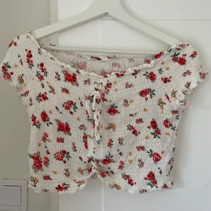 Topp från Bershka - Supersöt blommig topp från Bershka!! Väldigt sparsamt använd :-) etiketten har klippts bort men jag skulle säga att den passar som en S, i.om att toppen är elastisk går den dock även att ha om man är M! Toppen är väldigt kort