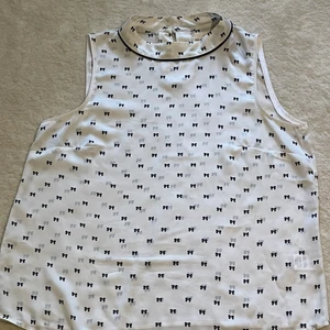 En svart, vit blus  - En vit blus med små svarta rosetter, har endast användes ett få tal gånger. 