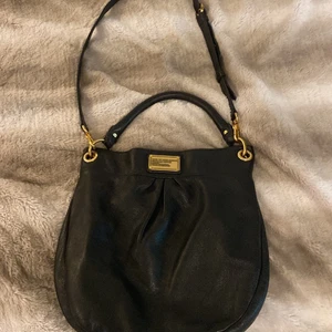 Marc by Marc Jacobs väska läder - Säljer stor Marc by Marc Jacobs axelremsväska (valbart, axelremmen kan tas av) i svart läder. Väskan är inköpt 2015 men i mycket bra skick.  Mått:  Bredd - 32 cm Djup - 7 cm Höjd - 34 cm 
