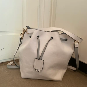 Vit väska - En vit väska med mycket utrymme. Vi vet inte riktigt vilket märke det är då det inte står och det var en present. Den har lite fläckar men inget man tänker på.